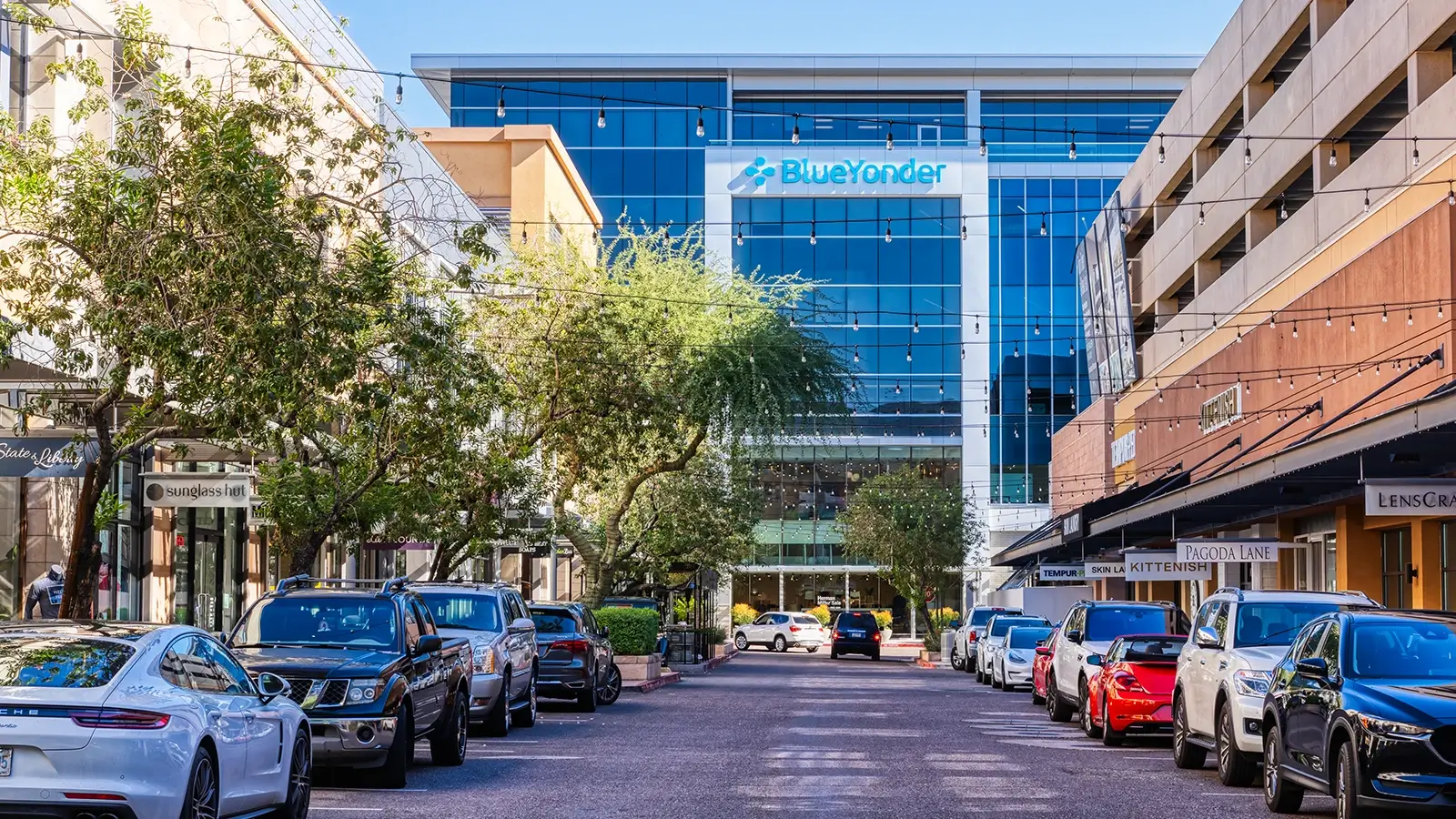 Street view of Blue Yonder headquarters in Scottsdale, Arizona. The building is modern, tall, and glass. The text on the building reads "Blue Yonder".