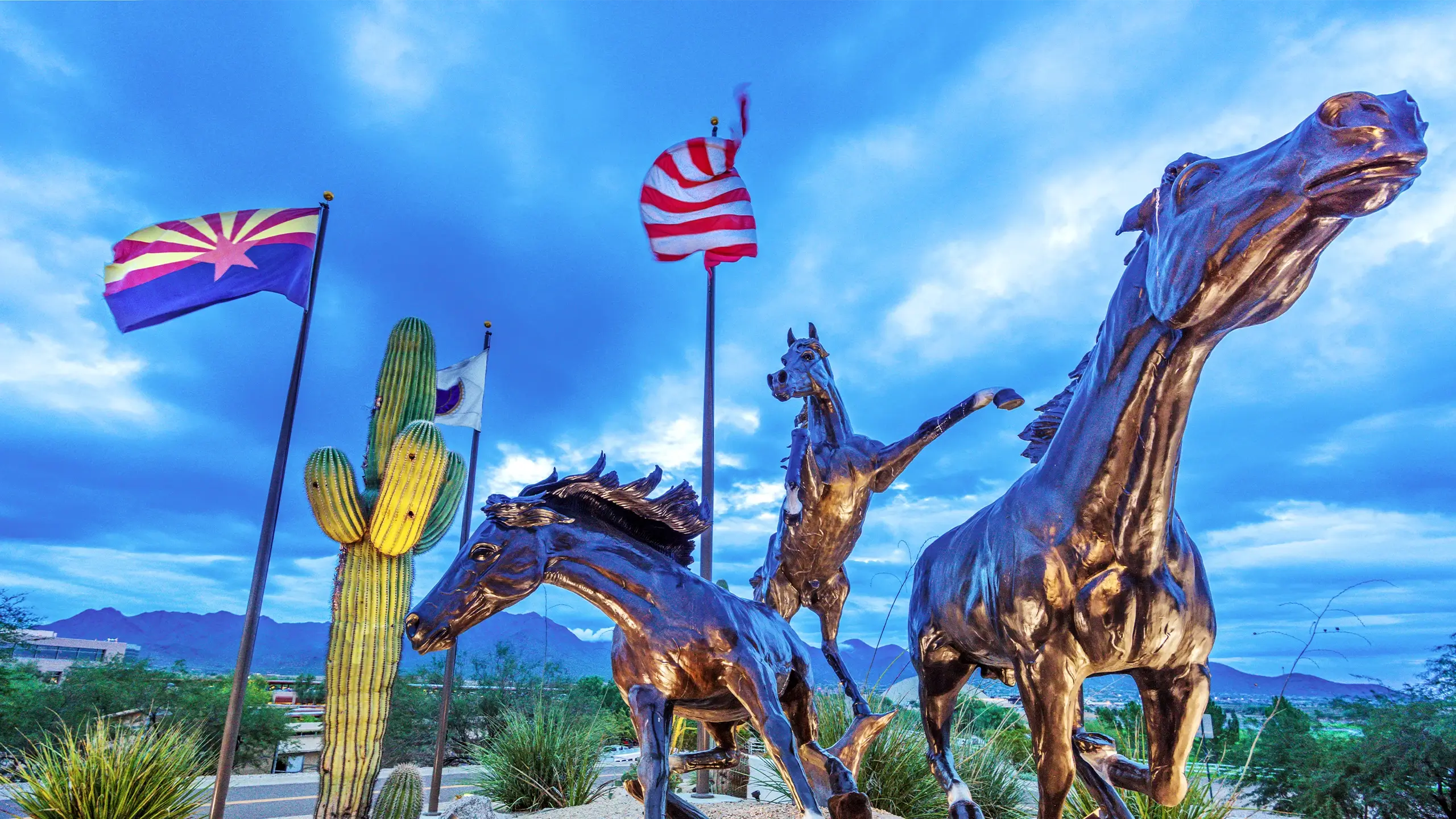 Scottsdale, Arizona is captured in this image of horse statues, flags, and saguaro cacti. The city's motto "Work Smart. Live Beautifully." is displayed.