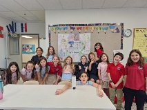 Kids around a desk taking a group photo.
